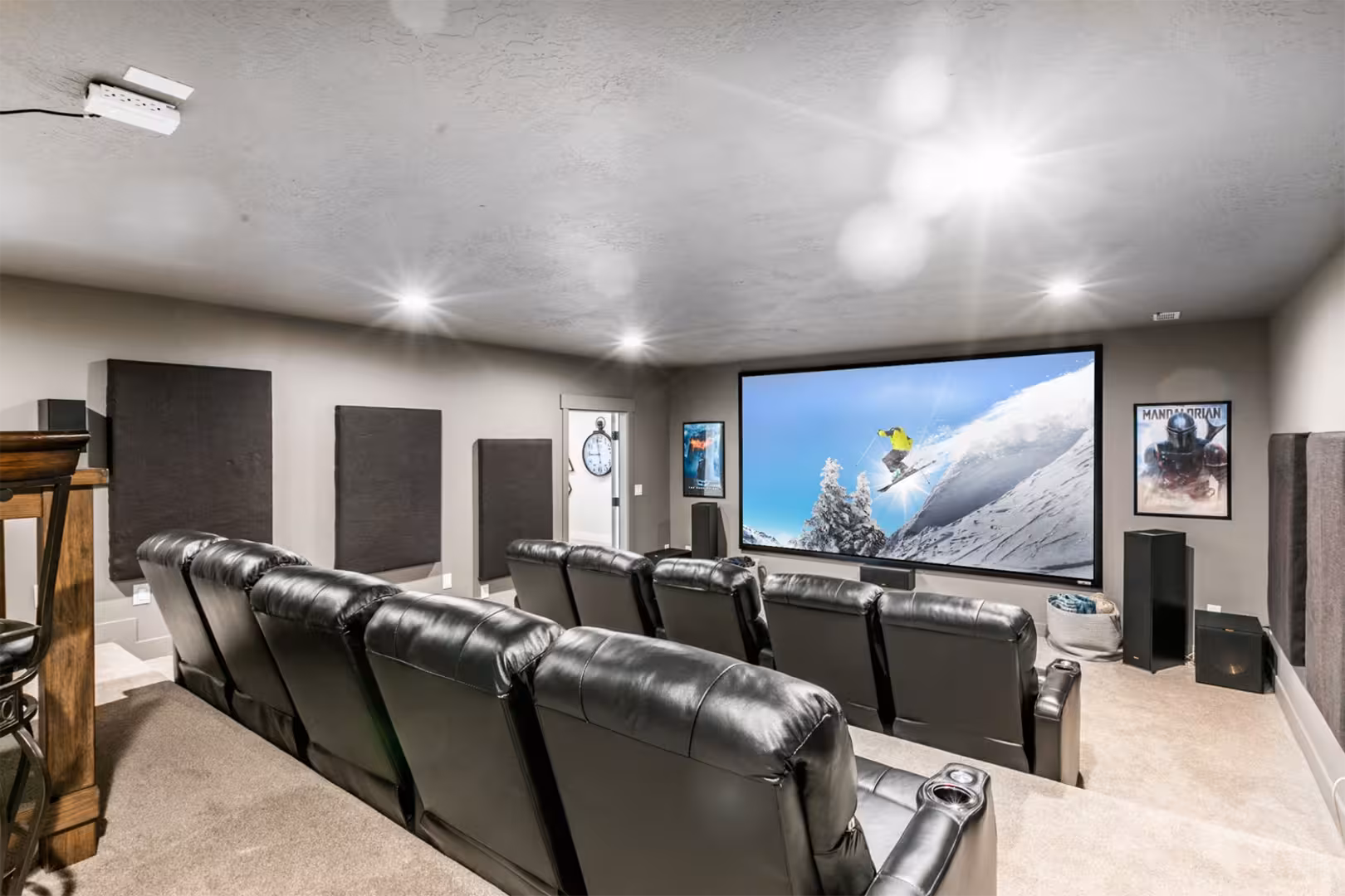Home theater in the Alpine home with tiered leather recliners and a large projection screen