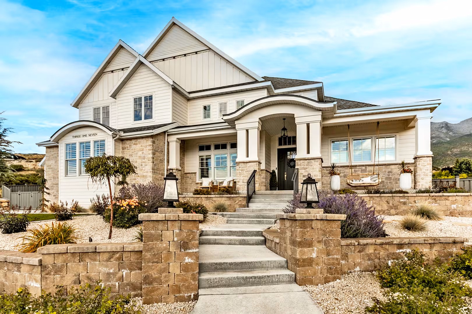 Stone steps and lantern pillars leading to the arched front porch of the Alpine home