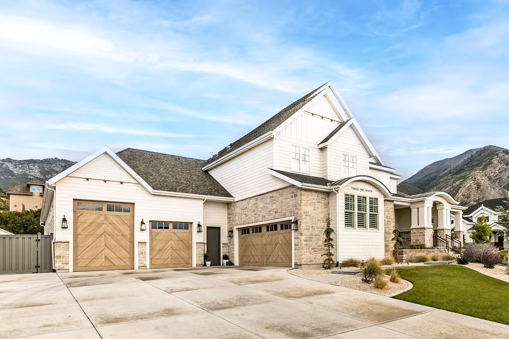 Three-car garage of the Alpine home with wood herringbone doors and mountains behind