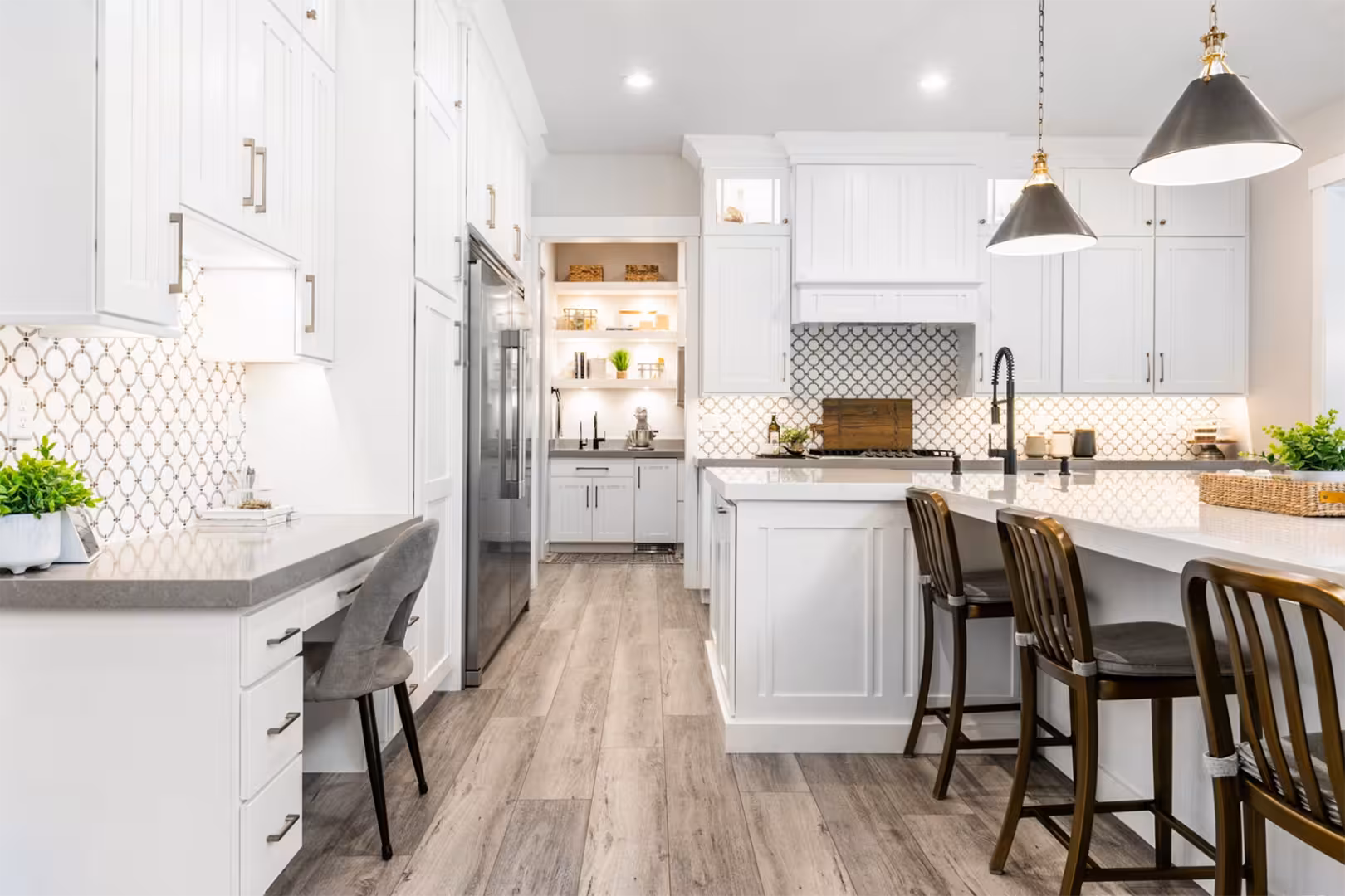 Alpine home kitchen with a built-in desk, patterned tile backsplash and white cabinets