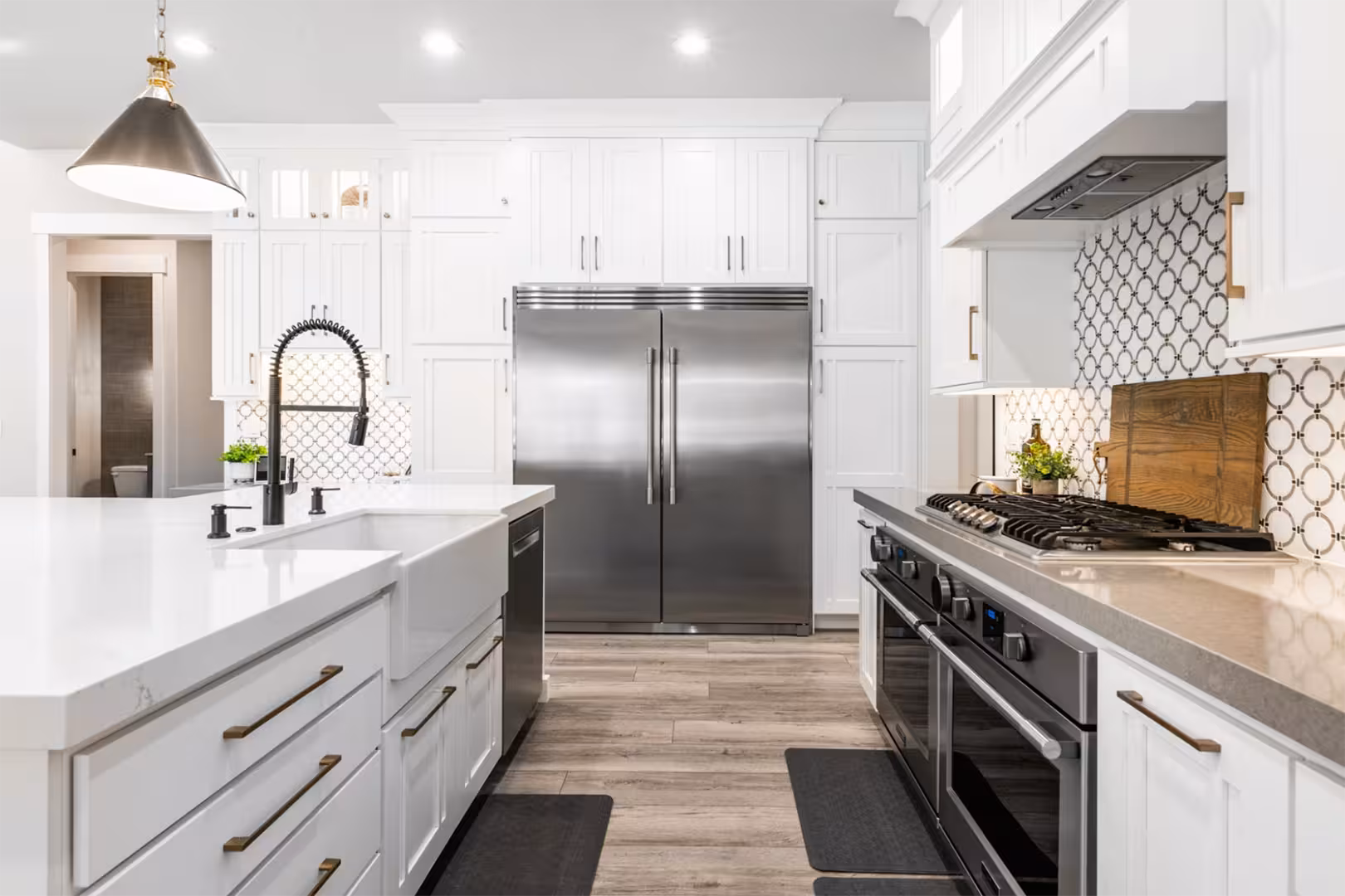 Farmhouse sink, stainless refrigerator and gas range in the white kitchen of the Alpine home