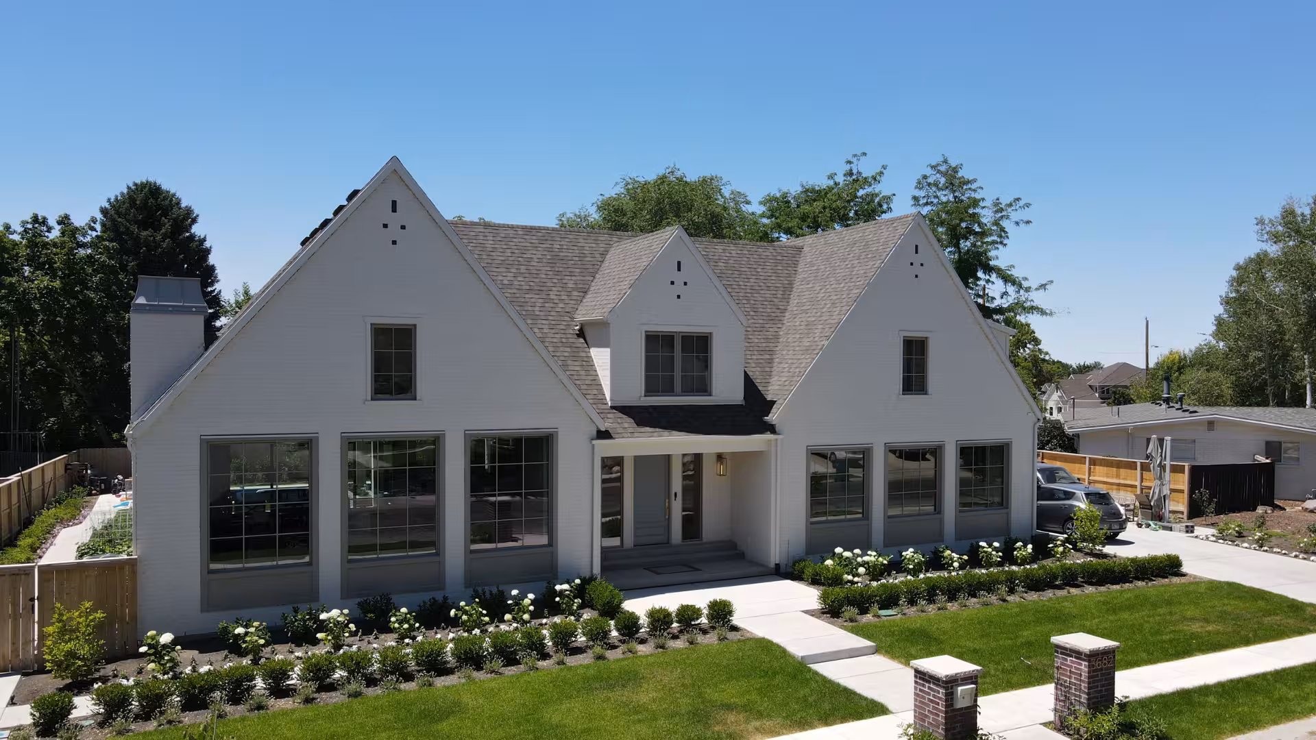 Front of the Haven home with white siding, steep gables and rows of black-framed windows