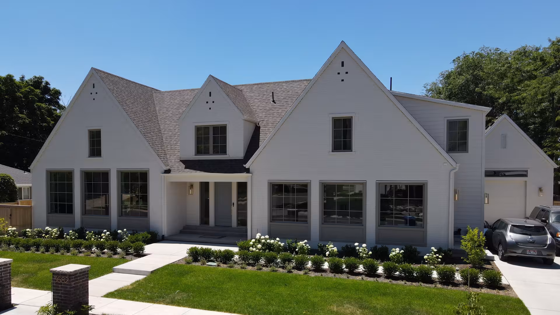 Haven home street view with twin front gables, a recessed entry and boxwood hedges