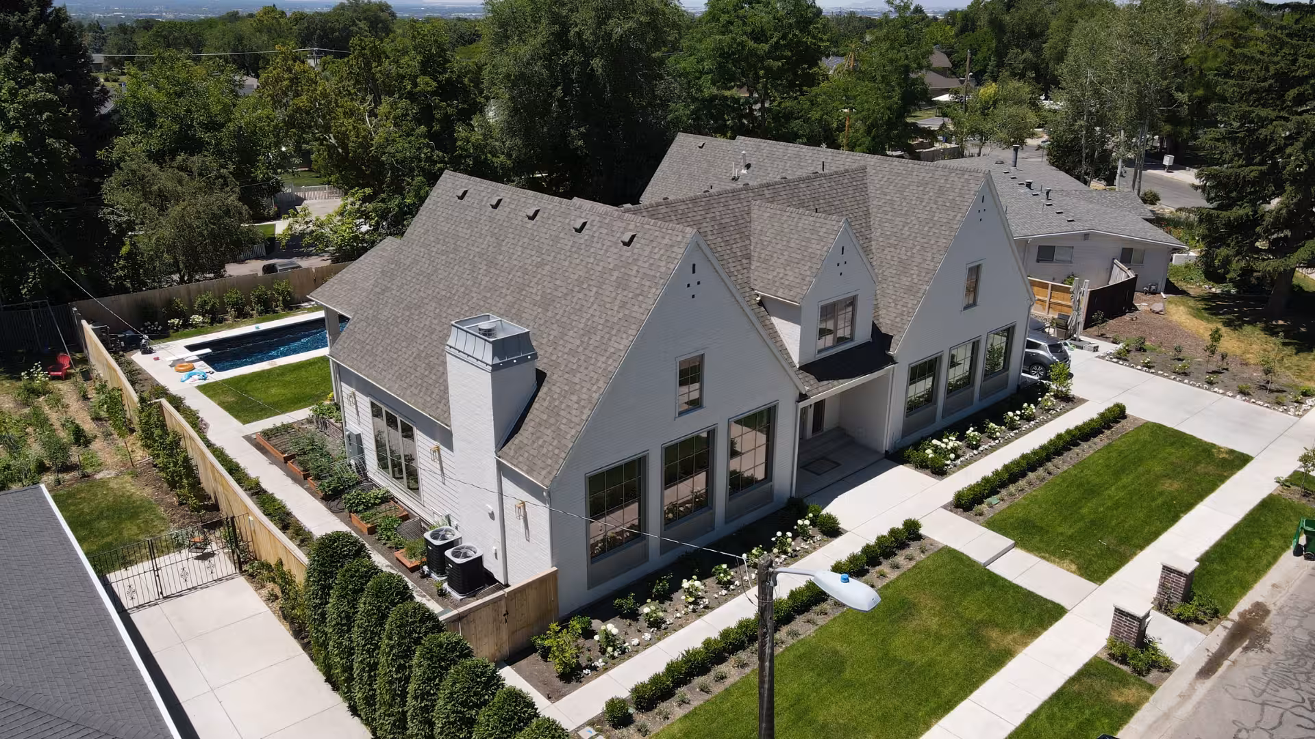 Aerial view of the Haven home with its backyard pool, steep gray roof and corner lot