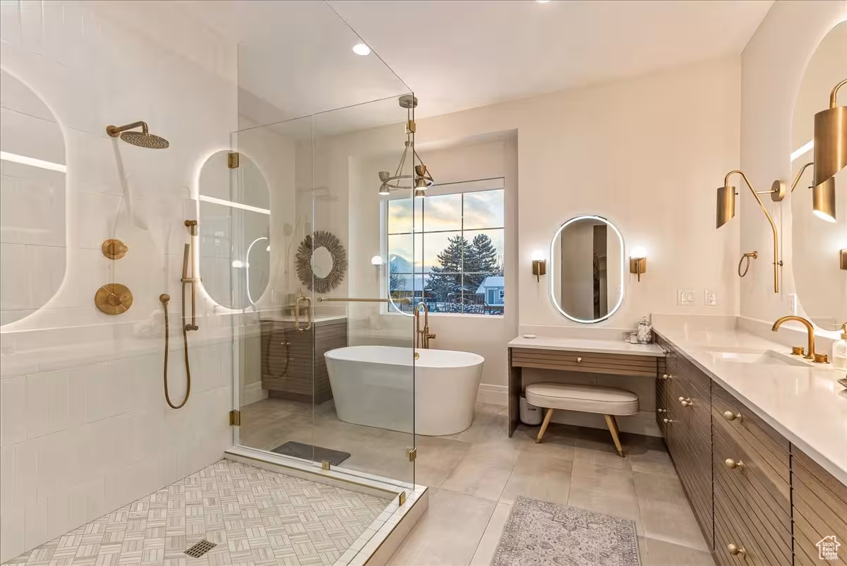 Primary bathroom in the Bountiful home with a glass shower, freestanding tub and backlit mirrors