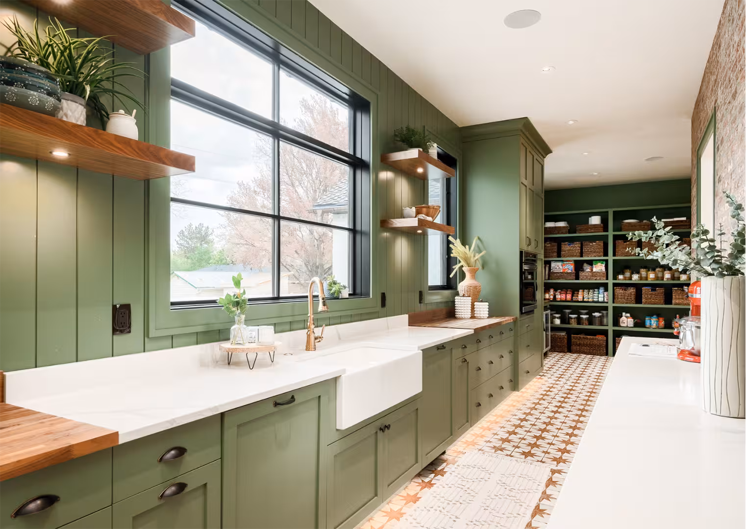 Green butler's pantry in the Draper home with a farmhouse sink, wood shelves and a walk-in pantry
