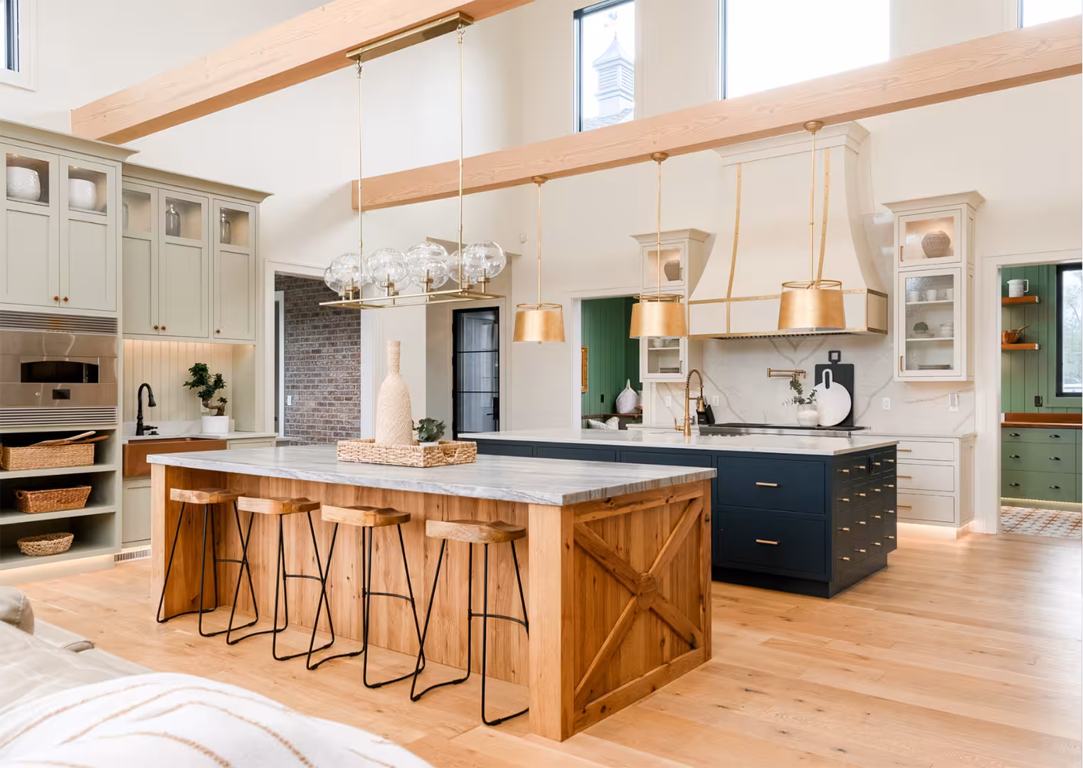 Draper home kitchen with two islands, one in rustic wood and one in navy, under a two-story ceiling
