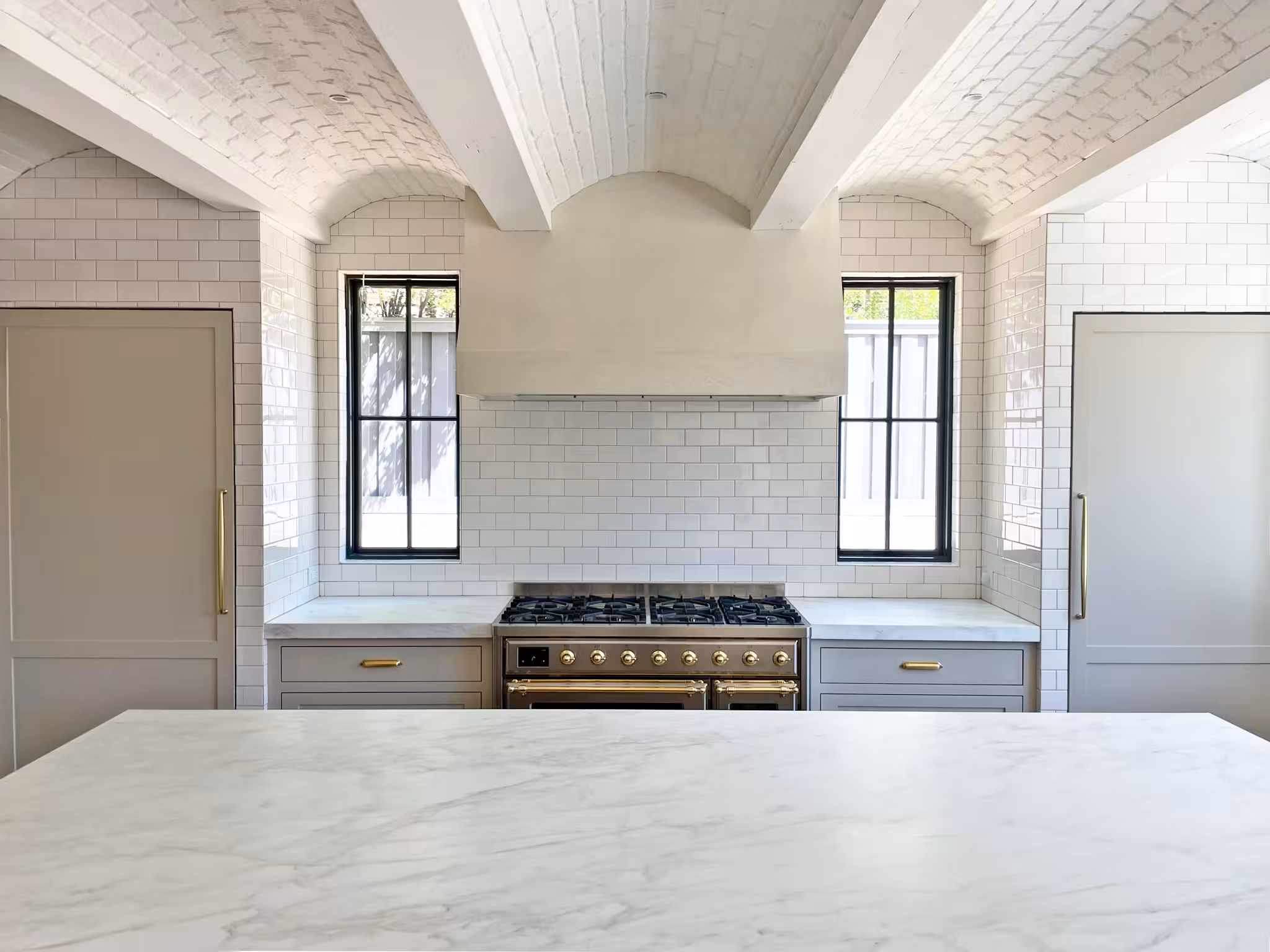 Holladay kitchen range wall with a plaster hood, white subway tile and black-framed windows