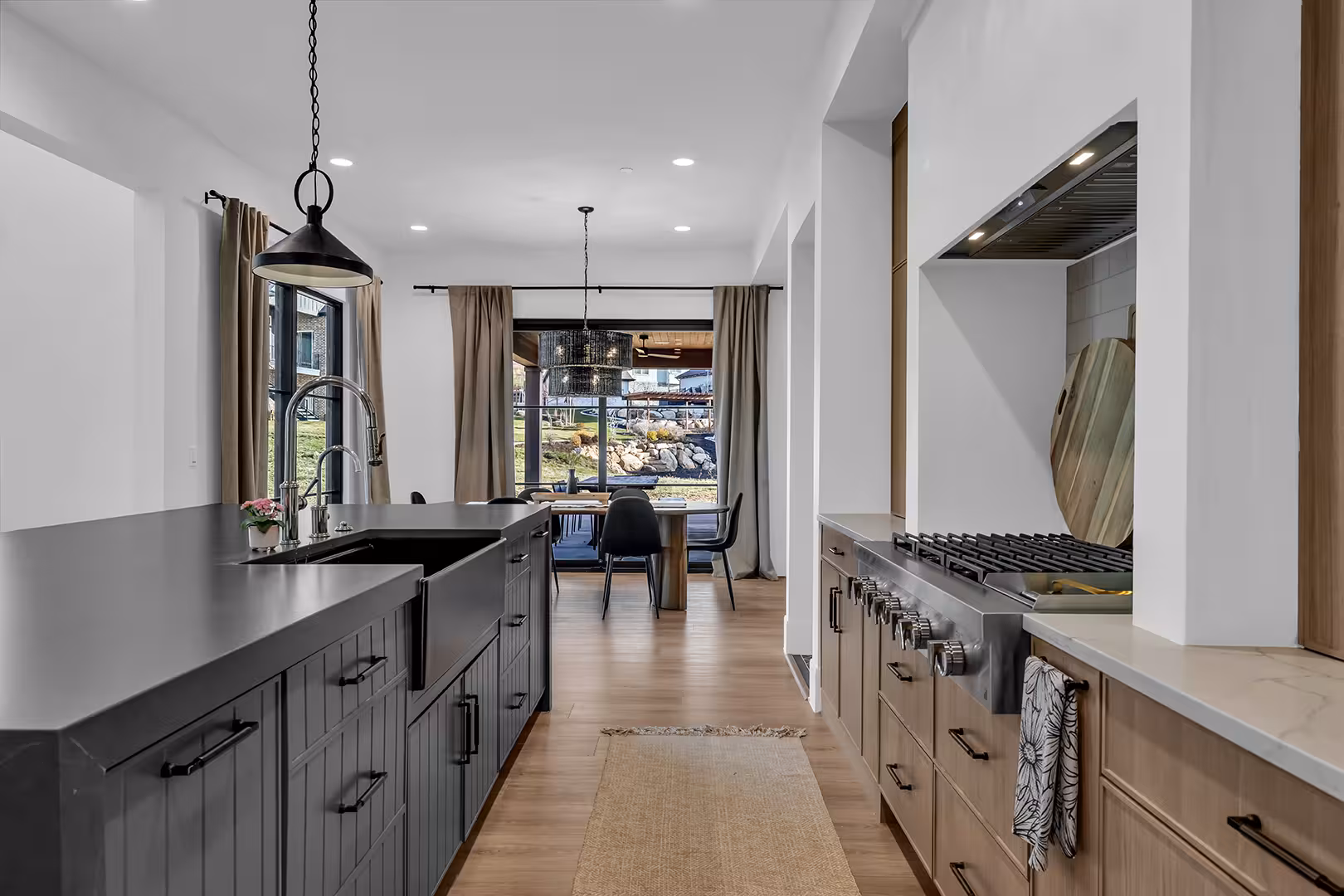 Galley view of the Elk Ridge kitchen with a gas range, wood cabinets and the dining area beyond