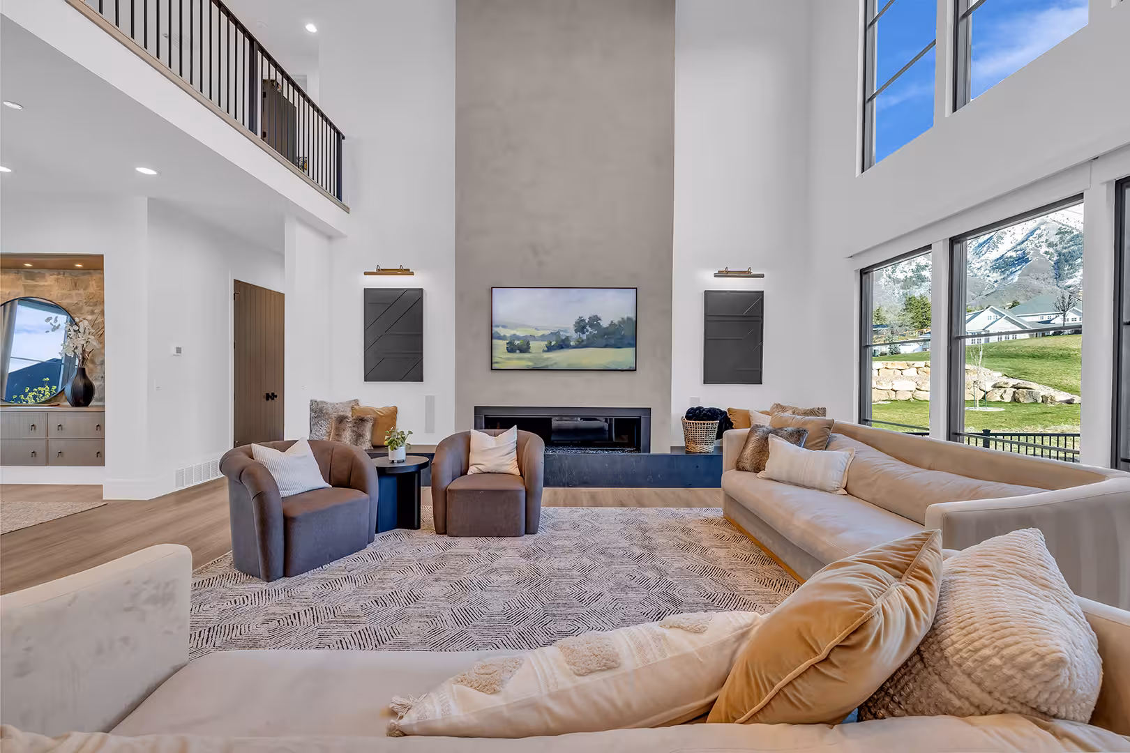 Elk Ridge great room with a two-story plaster fireplace wall and an upstairs iron railing