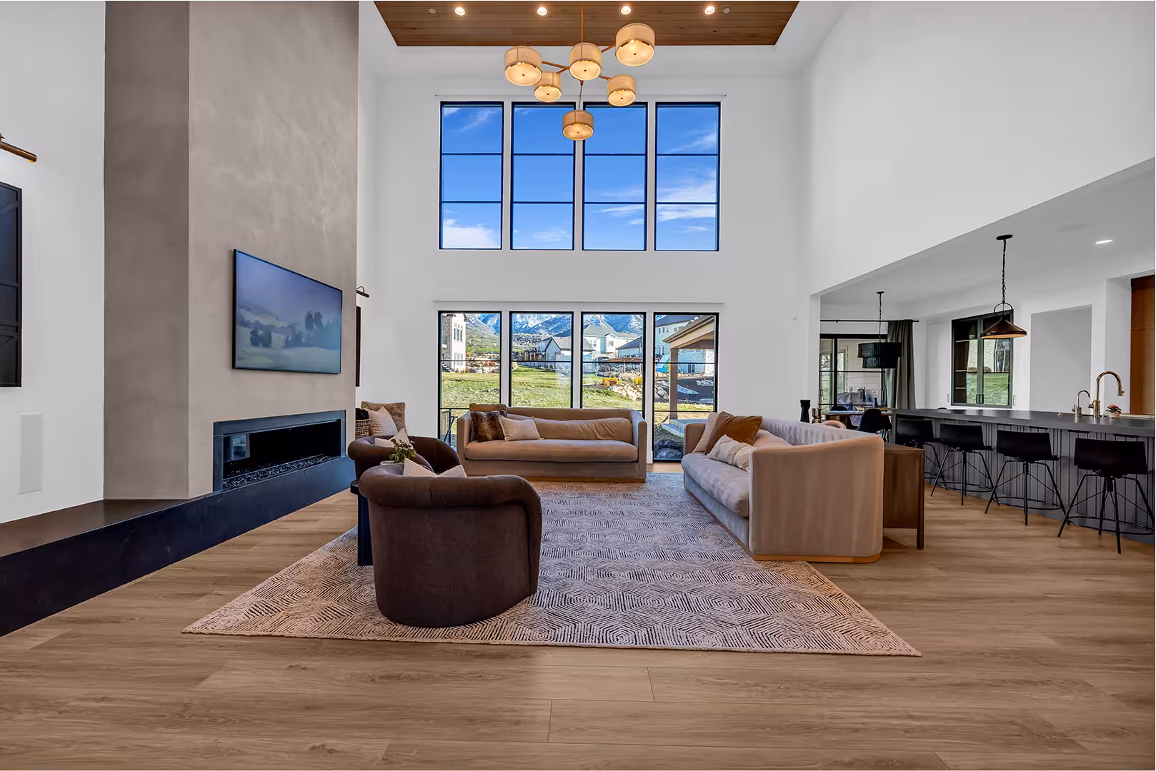 Elk Ridge living room open to the kitchen, with tall windows and a wood ceiling inset
