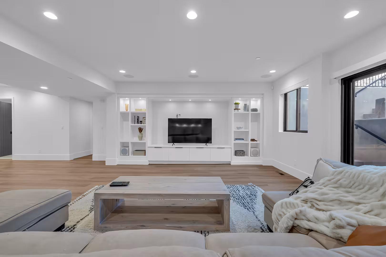 Basement family room in the Elk Ridge home with built-in shelves around the TV