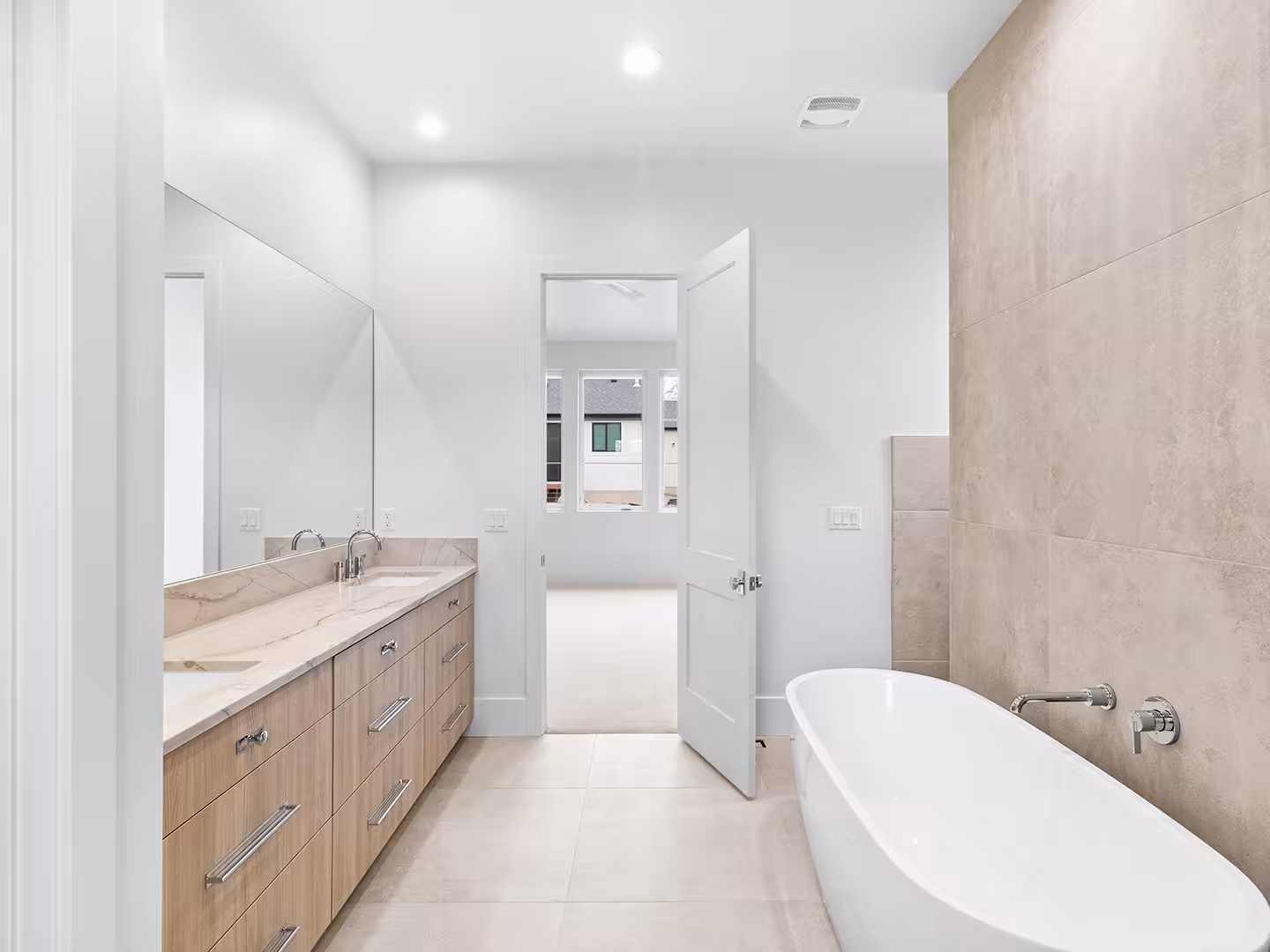 Primary bathroom in the Jordan home with a freestanding tub and a large-format tile wall