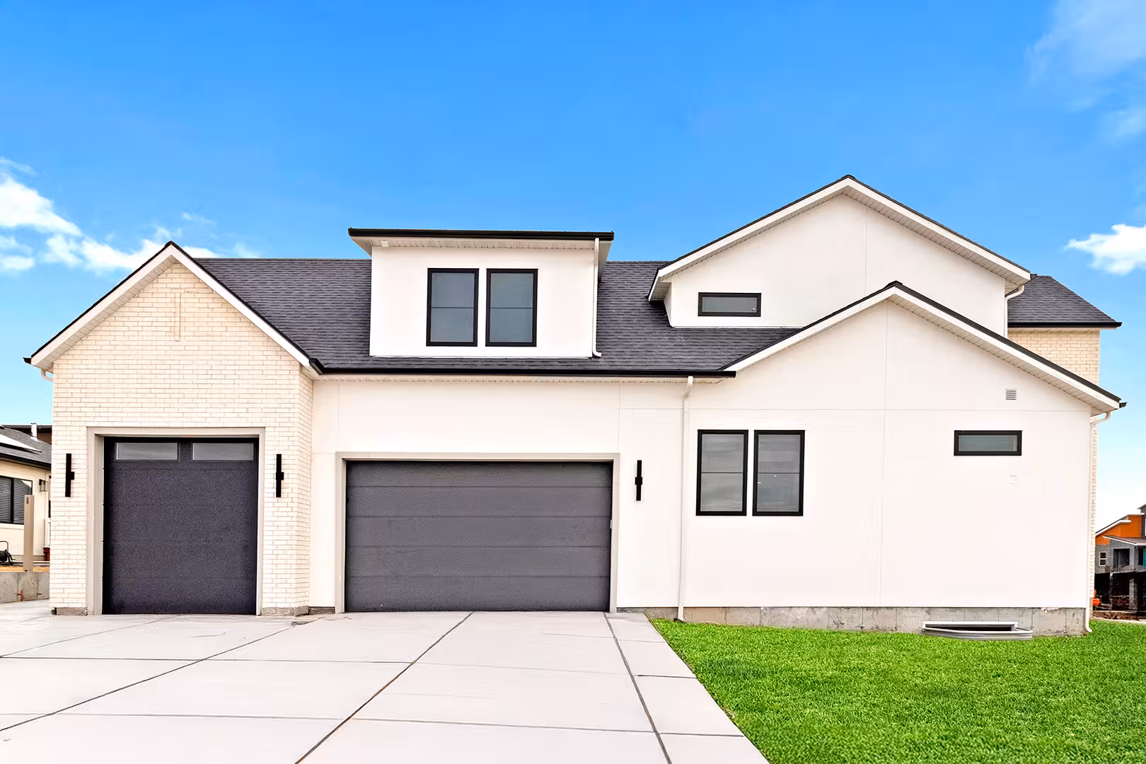 Garage side of the Jordan home with charcoal doors, white brick and black windows
