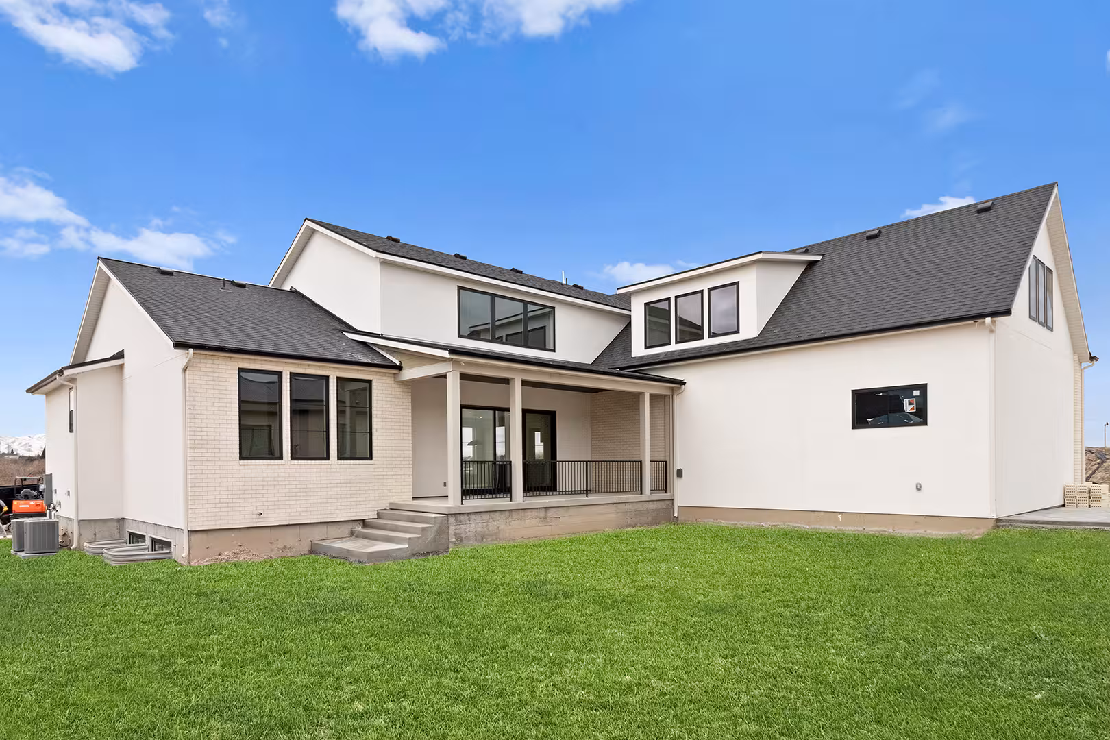Back of the Jordan home with a covered patio and steps down to the lawn
