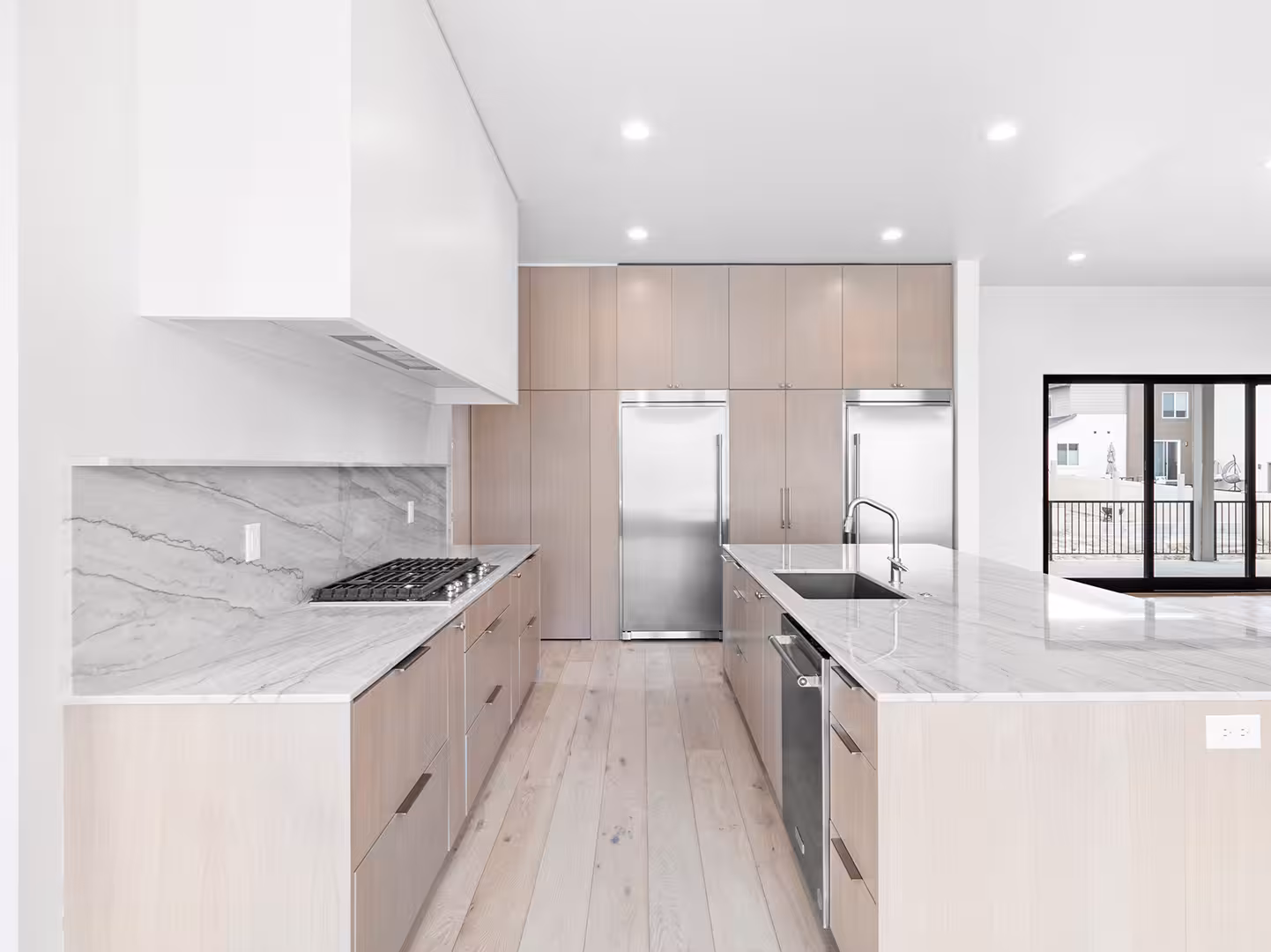 Marble counters and paired stainless refrigerators in the Jordan kitchen