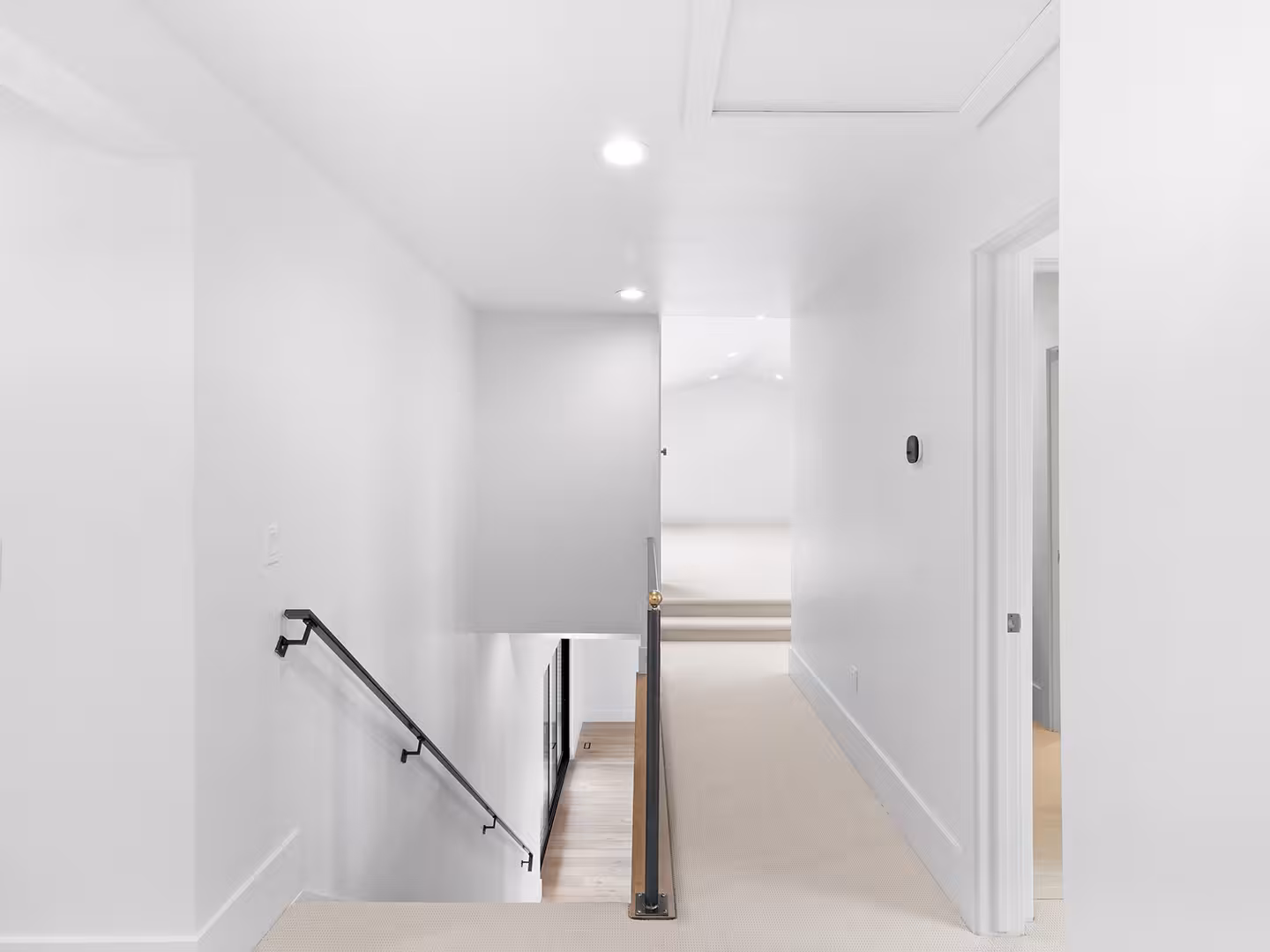 Upstairs landing in the Jordan home with a black handrail over the stairwell