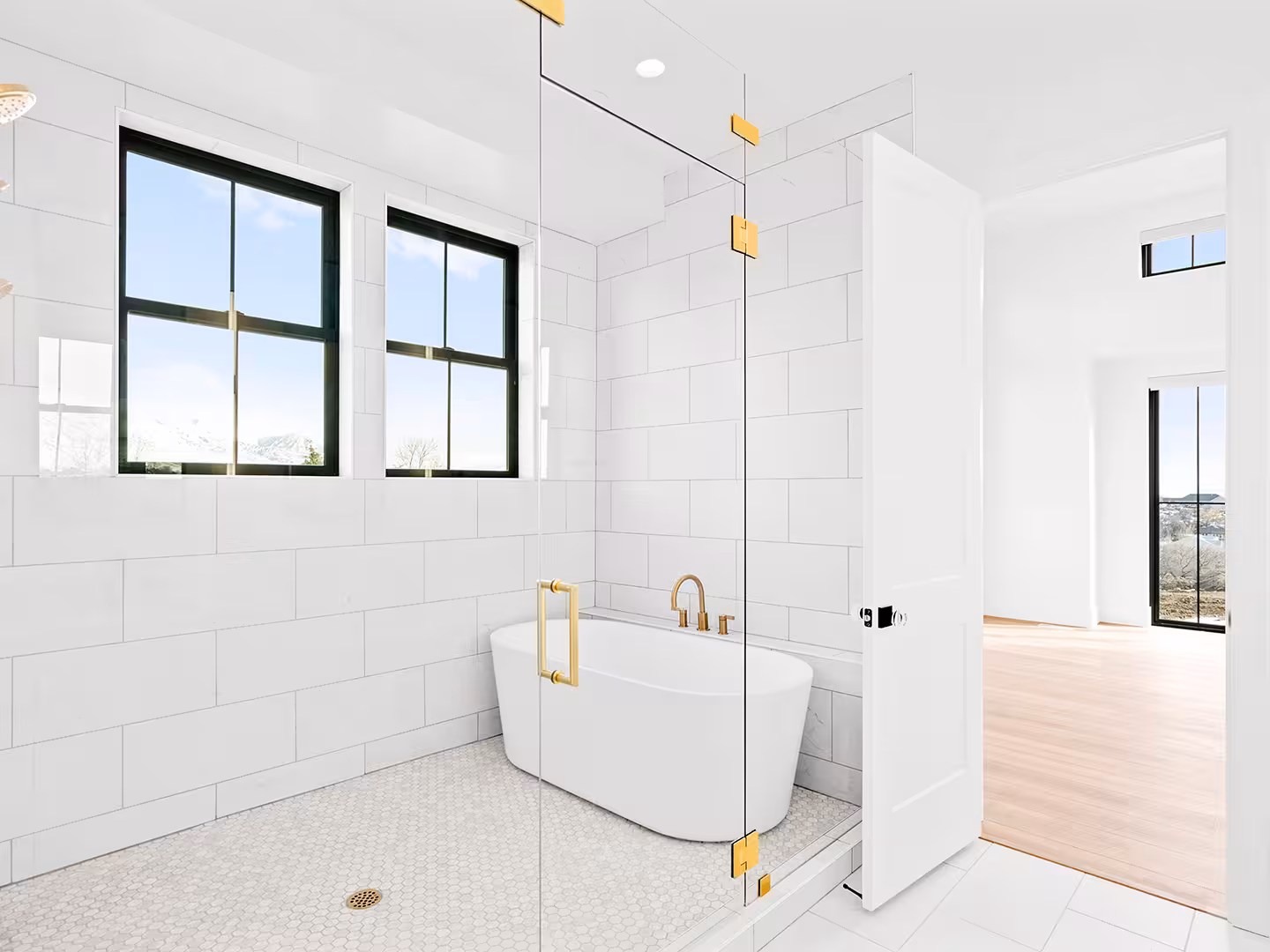 Primary bathroom in the Lehi home with a freestanding tub inside a glass wet room and black windows