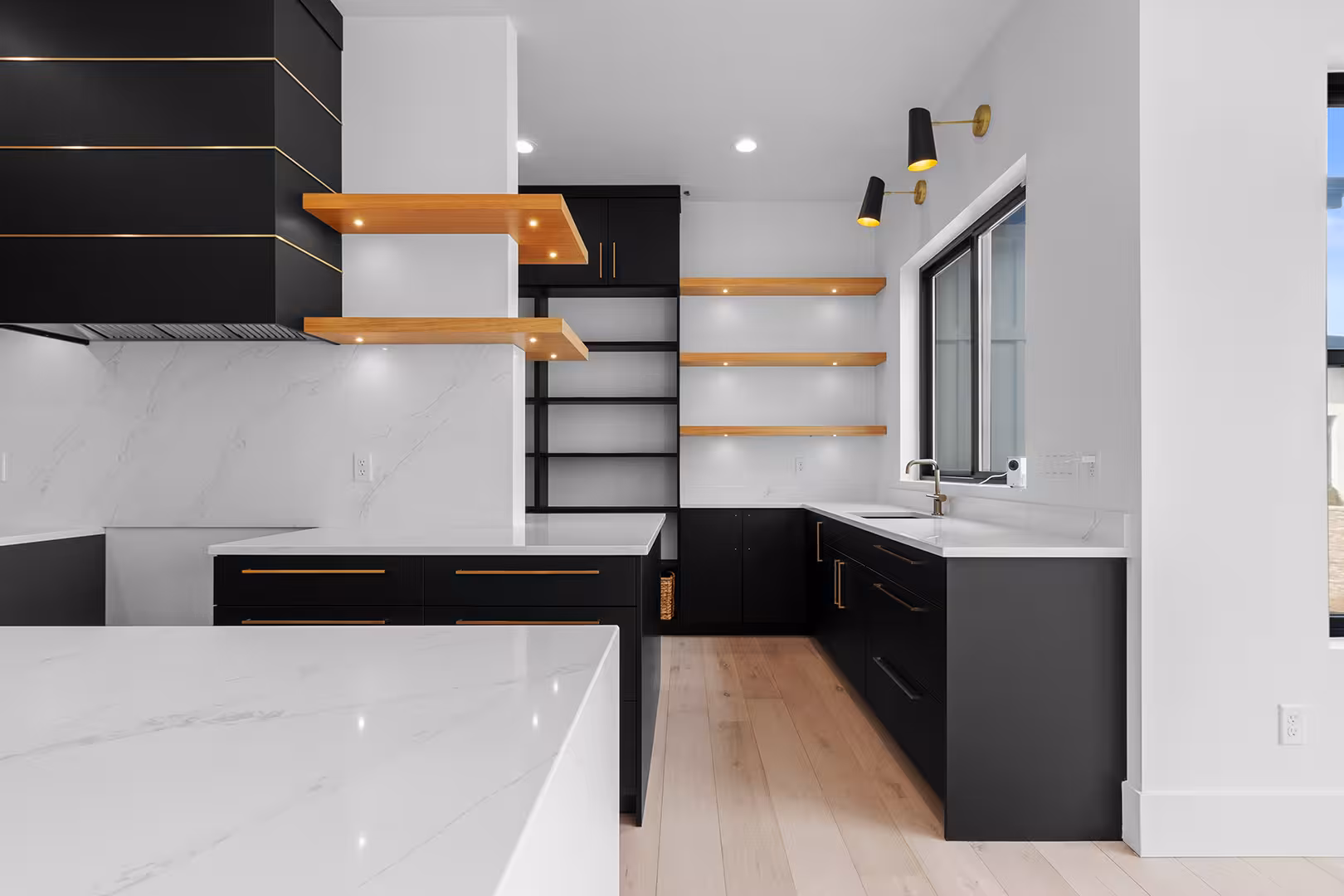 Floating wood shelves and black cabinets against white stone counters in the Meadow kitchen