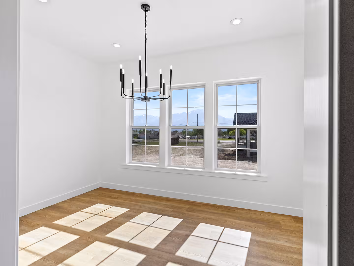 Dining room in the Paradise home with a black candle chandelier and three windows