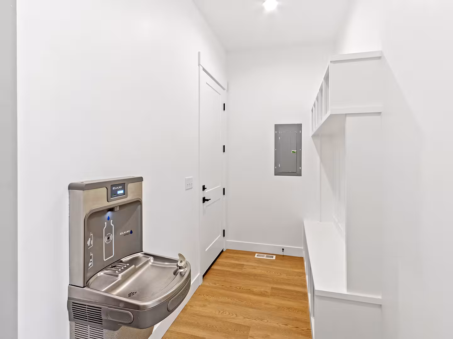 Mudroom in the Paradise home with built-in white cubbies and a bottle-filling water station