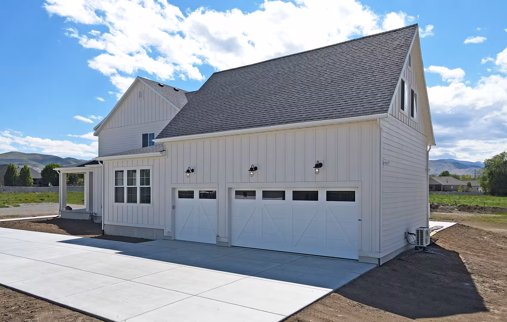 Three-car garage side of the Paradise home with white carriage-style doors
