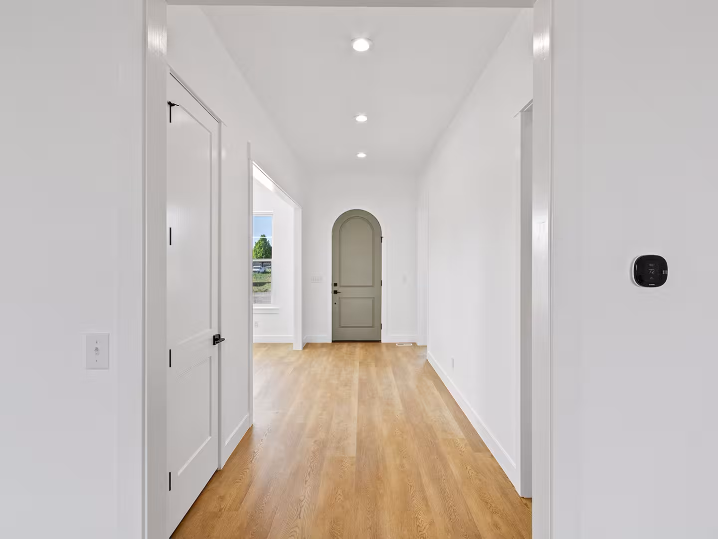Hallway in the Paradise home leading to an arched gray door