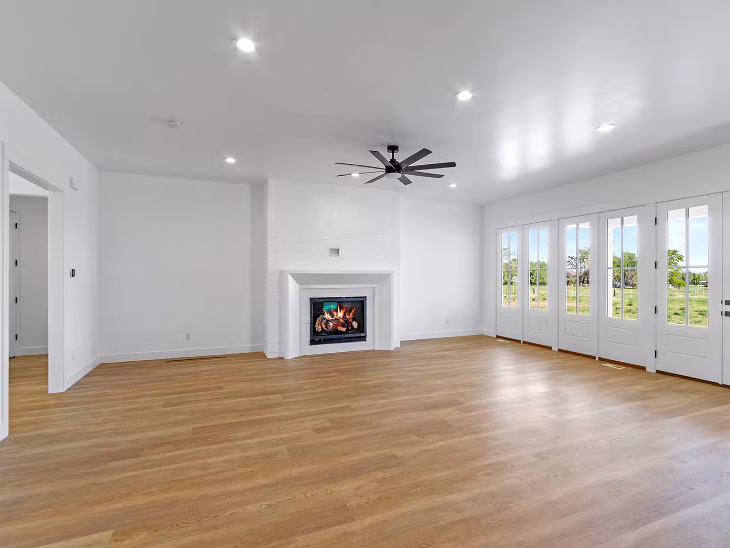 Paradise home living room with a white fireplace surround and a wall of French doors