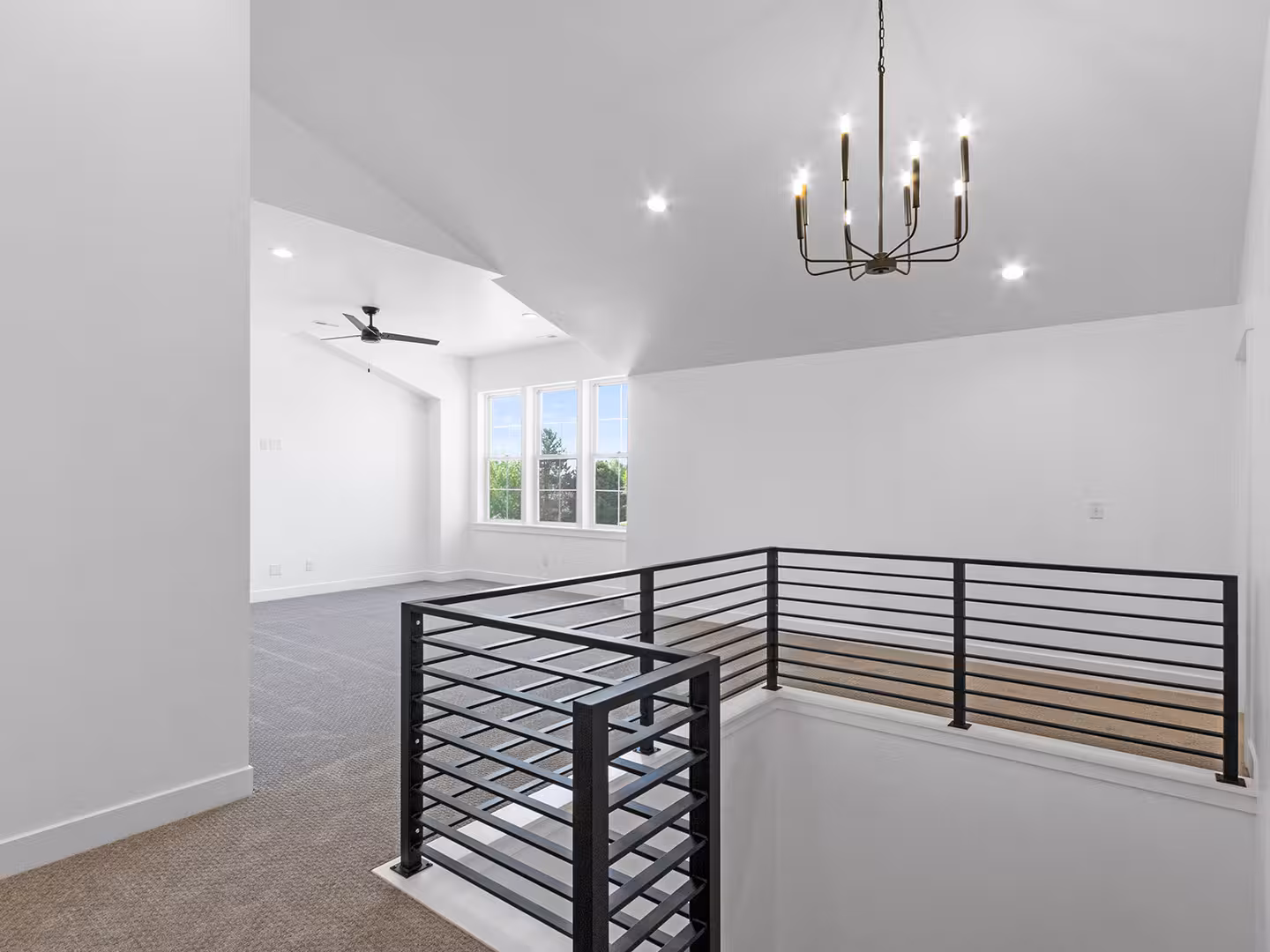 Upstairs loft in the Paradise home with a black horizontal stair railing and a vaulted ceiling