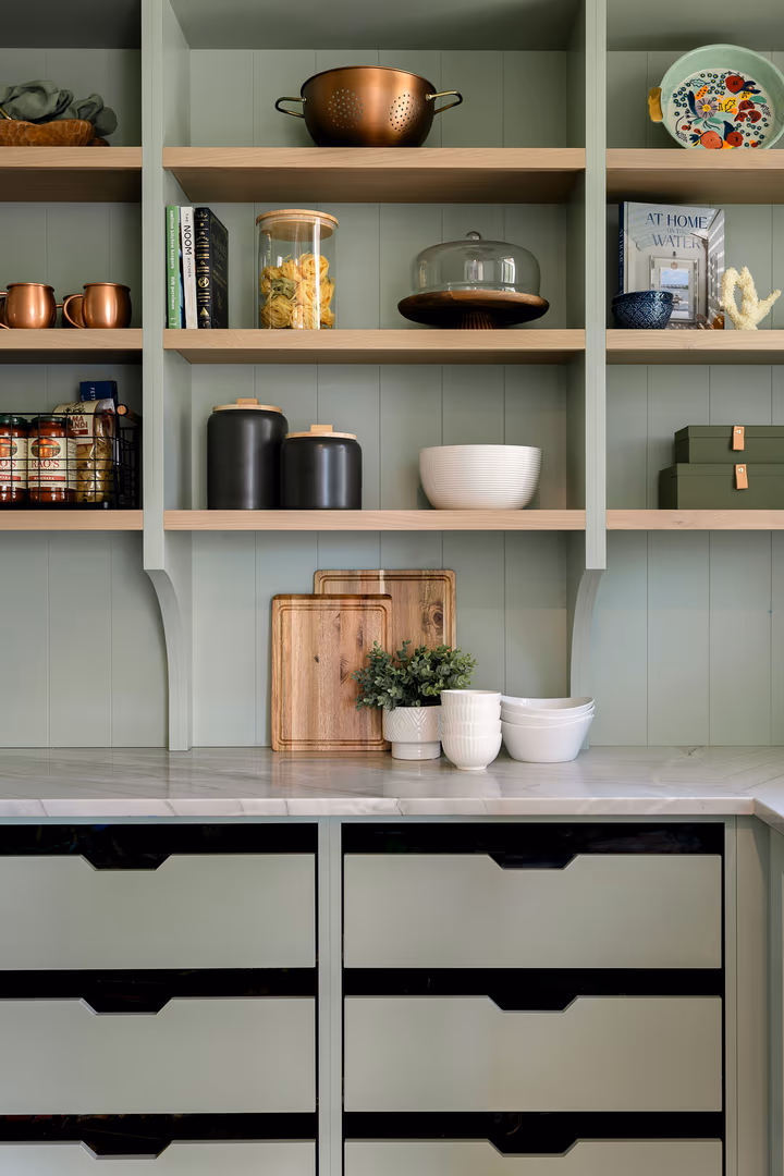 Sage green pantry shelves and drawers in the Perry home