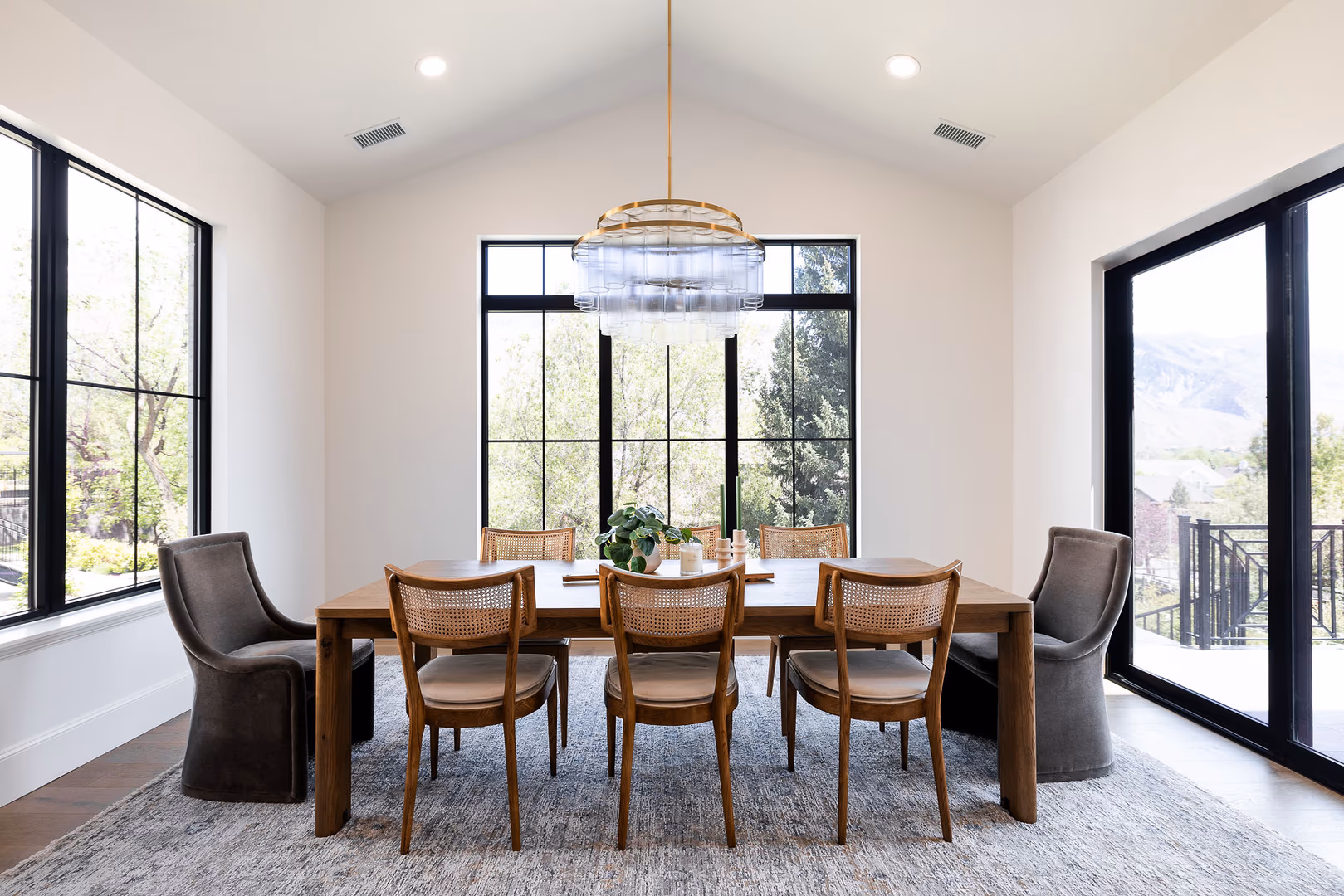 Perry home dining room with a vaulted ceiling, wood table and black-framed windows