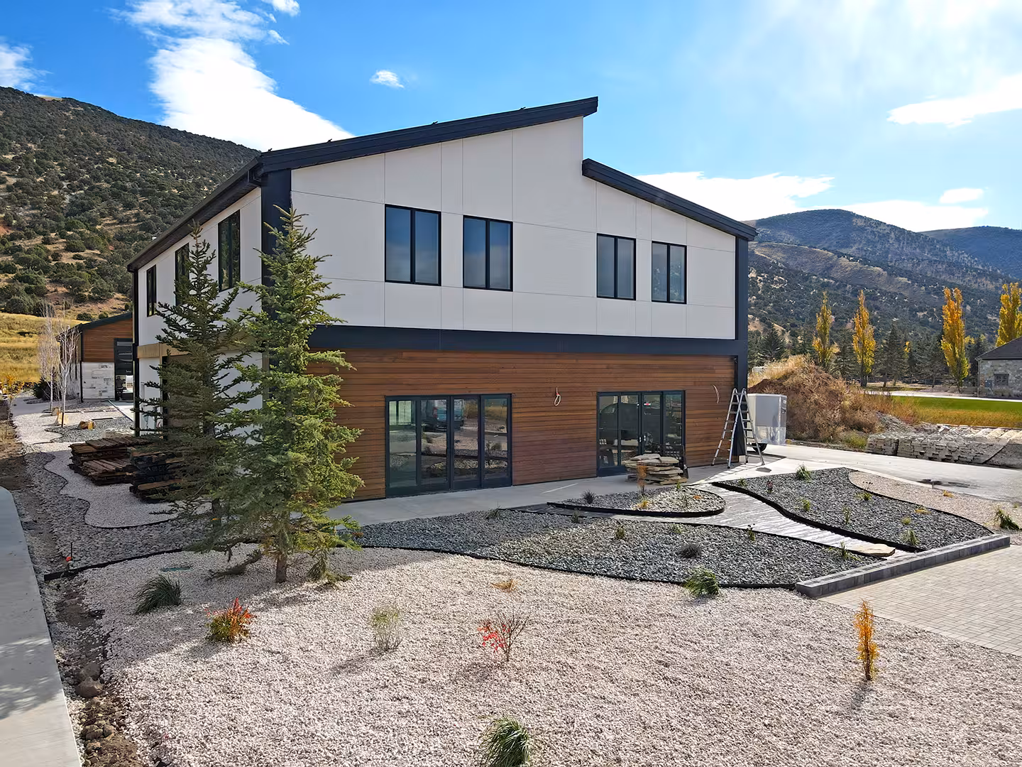 Side of the Plymouth home with a shed roof, wood lower siding and gravel landscaping