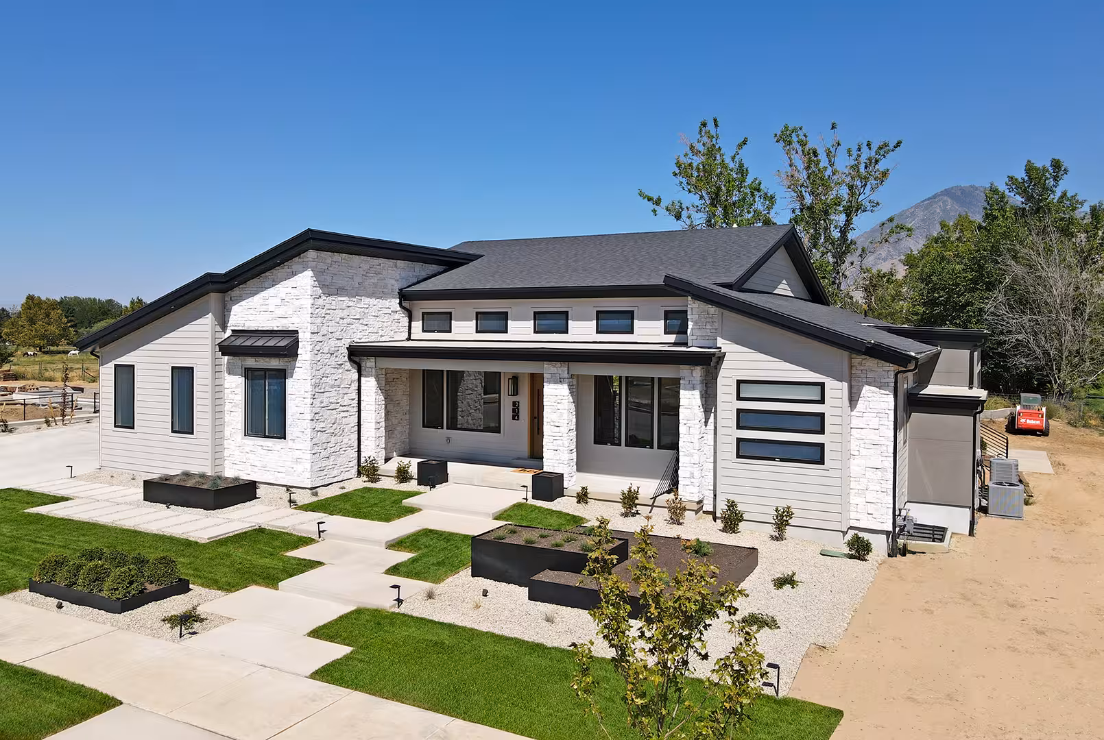 Rockville home from the yard, with a clerestory window row and white stone columns