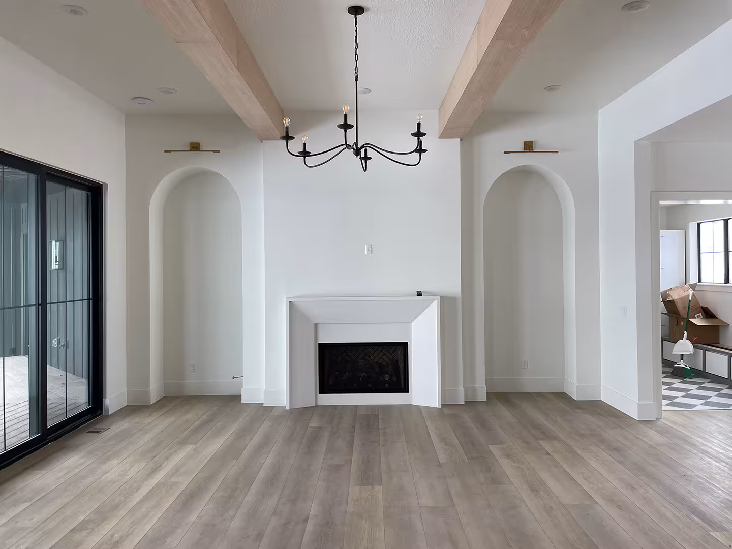 Syracuse home living room with wood beams, arched wall niches and a white fireplace