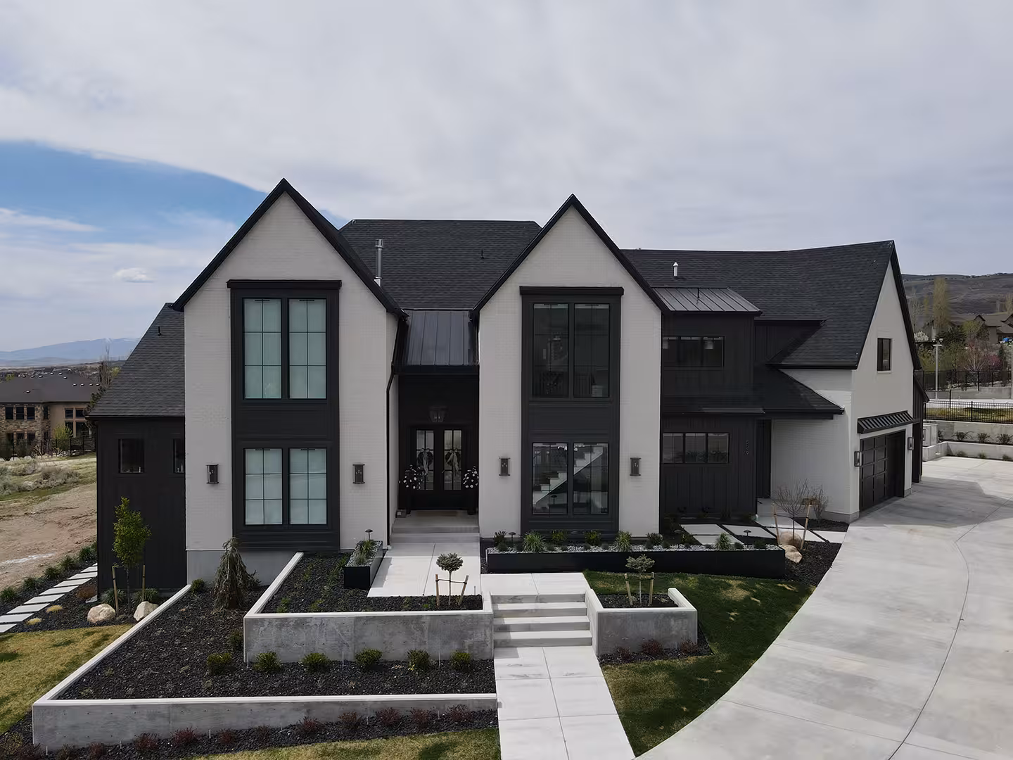 Syracuse home front with tall black windows in two white gables and a front walk