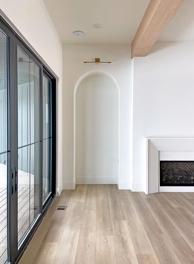 Arched niche and fireplace beside black sliding doors in the Syracuse living room