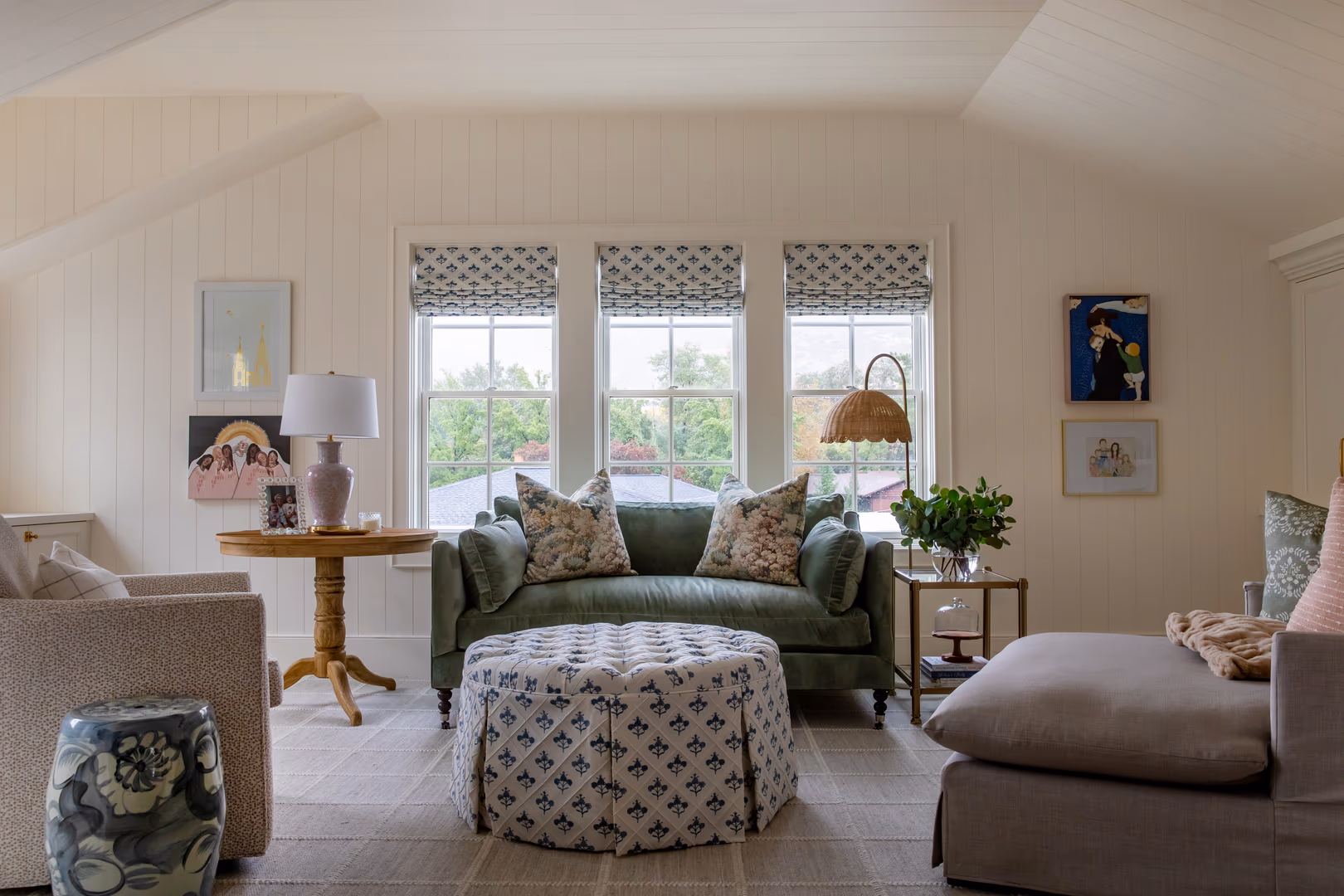 Sitting room in the Vineyard home with a green sofa, skirted ottoman and paneled walls