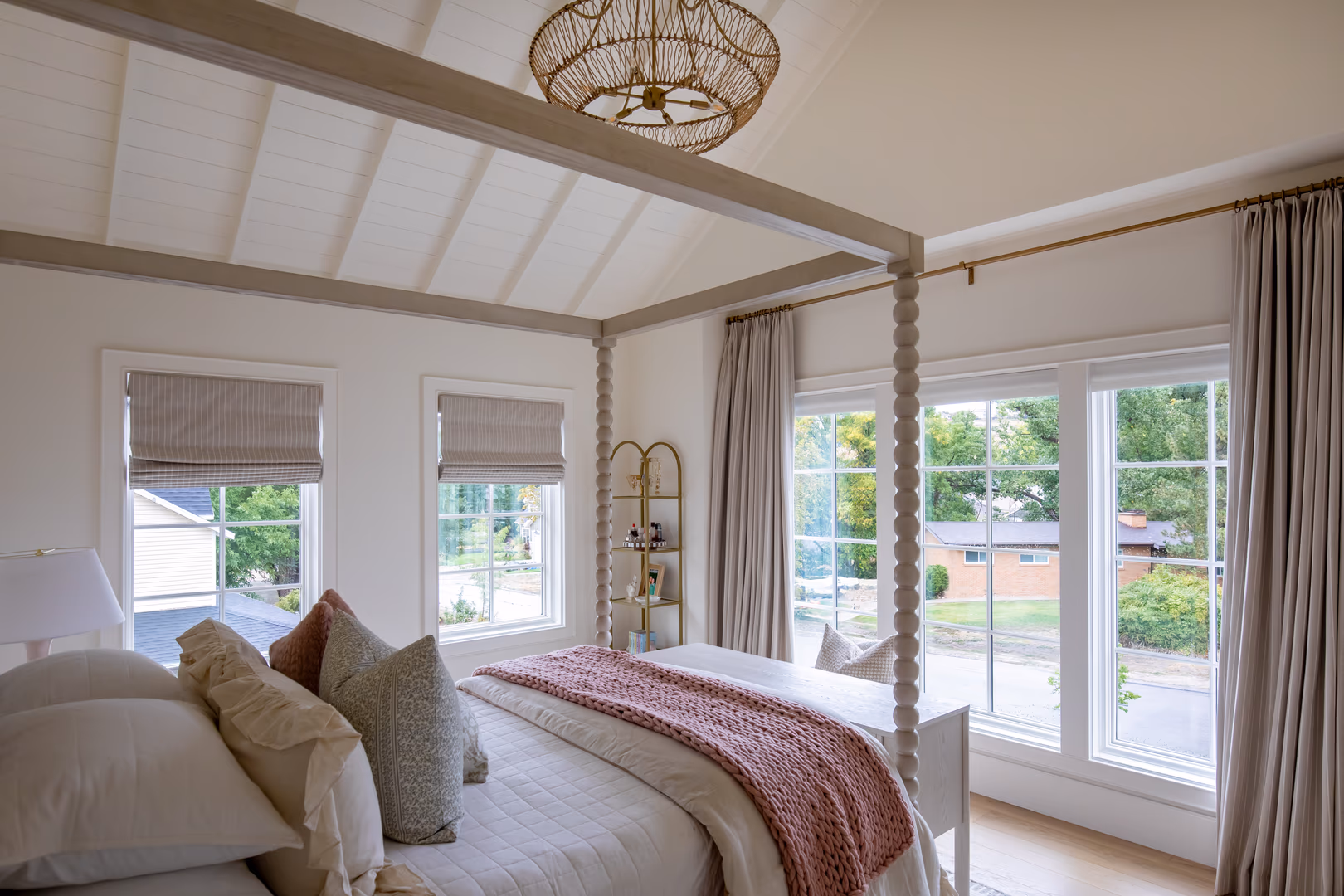 Vineyard bedroom with a spindle canopy bed and windows on two walls