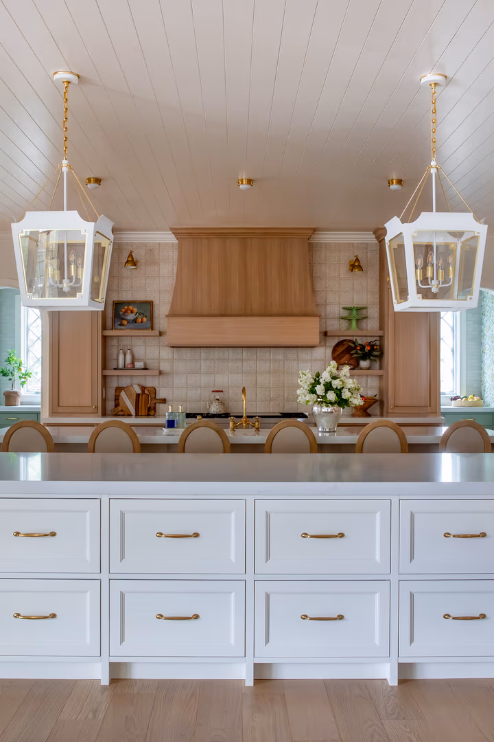 Front view of the white Vineyard kitchen island facing the wood hood and tile backsplash