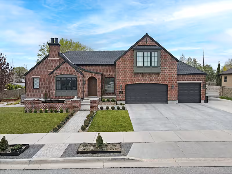 After the remodel: brick home with a new gabled front and a three-car garage